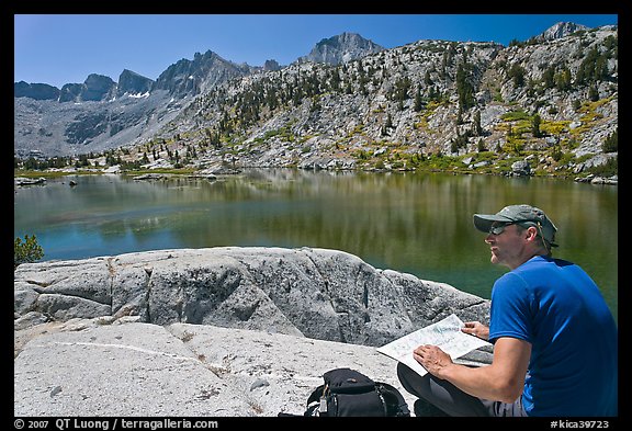 Hiker with map near lake, lower Dusy Basin. Kings Canyon National Park, California (color)