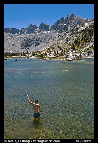 Man standing in alpine lake, lower Dusy Basin. Kings Canyon National Park, California