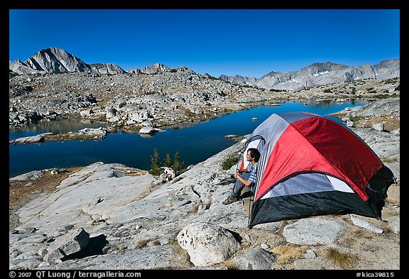 Man sitting in tent above lake, Dusy Basin. Kings Canyon National Park, California