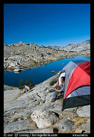 Man looking out from tent above lake, morning, Dusy Basin. Kings Canyon National Park, California (color)
