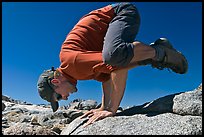 Hiker balancing on hands on rock, Bishop Pass. Kings Canyon National Park, California