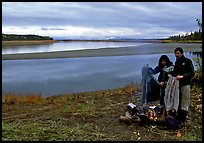 Canoeist drying out clothing over a campfire. Kobuk Valley National Park, Alaska (color)