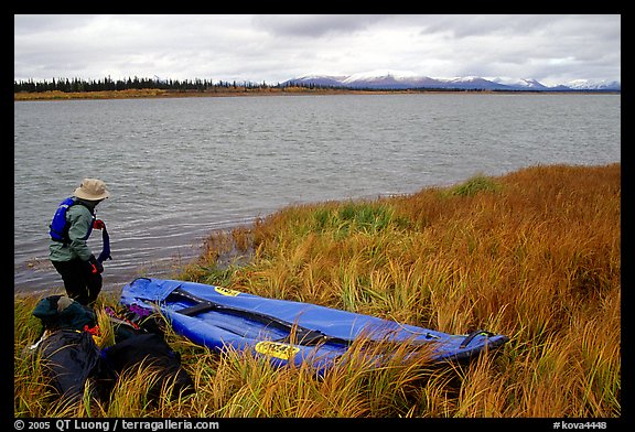 Canoeist deflating the canoe. Kobuk Valley National Park, Alaska (color)