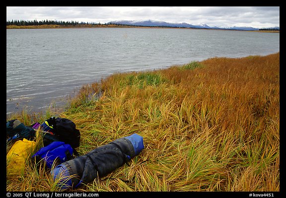 Gear and folded  canoe on a grassy riverbank of the Kobuk River. Kobuk Valley National Park, Alaska (color)