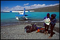 Backpackers dropped off by floatplane on Lake Turquoise orient themselves on the map. Lake Clark National Park, Alaska