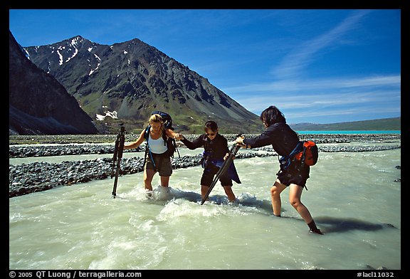 Hikers crossing a stream next to Lake Turquoise. Lake Clark National Park, Alaska (color)