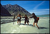 Hikers crossing a stream next to Lake Turquoise. Lake Clark National Park, Alaska