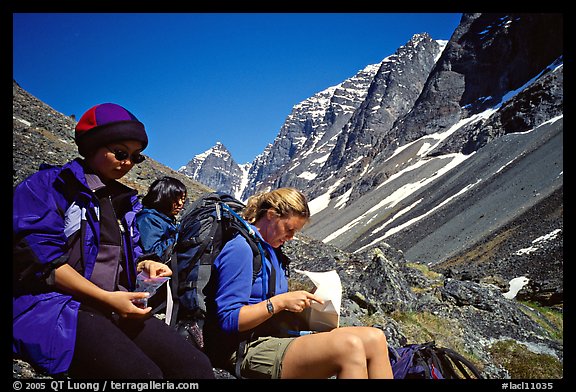 Women hikers pausing below the Telaquana Mountains. Lake Clark National Park, Alaska