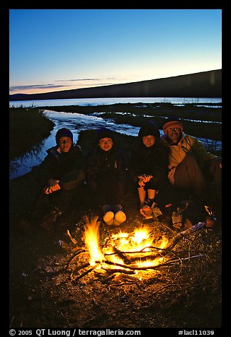 Campers warming toes in campfire next to Turquoise Lake. Lake Clark National Park, Alaska (color)