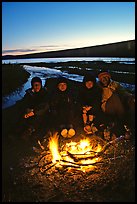 Campers warming toes in campfire next to Turquoise Lake. Lake Clark National Park, Alaska (color)