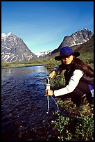 Woman filtering water from a stream. Lake Clark National Park, Alaska