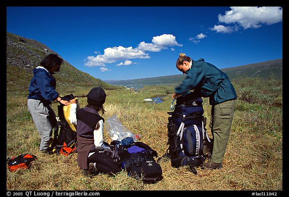 Backpackers breaking camp and readying backpacks. Lake Clark National Park, Alaska