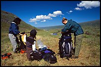 Backpackers breaking camp and readying backpacks. Lake Clark National Park, Alaska