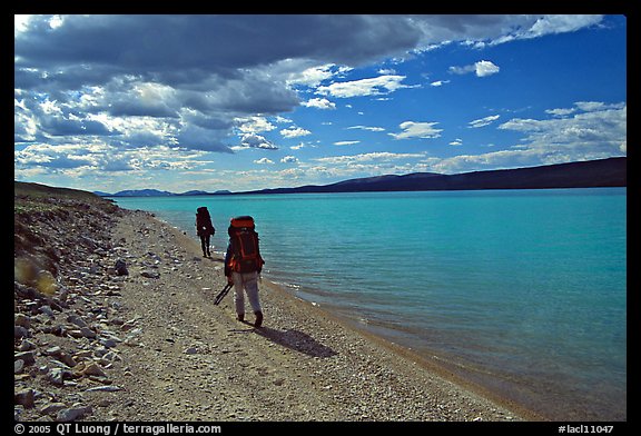 Backpackers walking on the shore of Turquoise Lake. Lake Clark National Park, Alaska