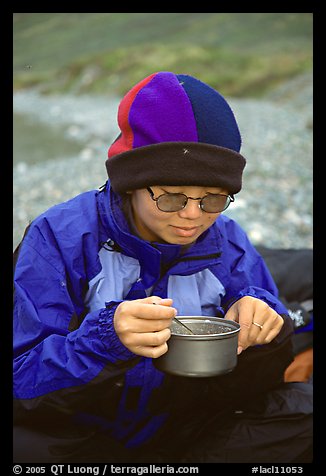 Backpacker eating camp food. Lake Clark National Park, Alaska