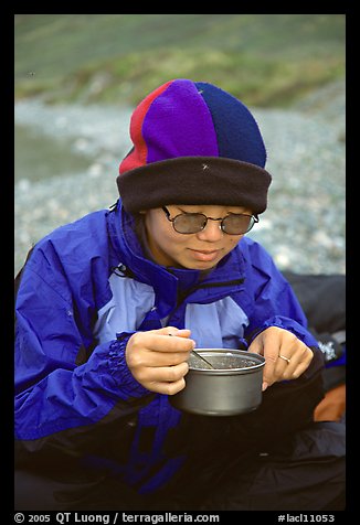 Backpacker eating camp food. Lake Clark National Park, Alaska (color)