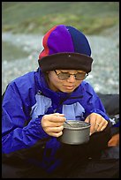 Backpacker eating camp food. Lake Clark National Park, Alaska