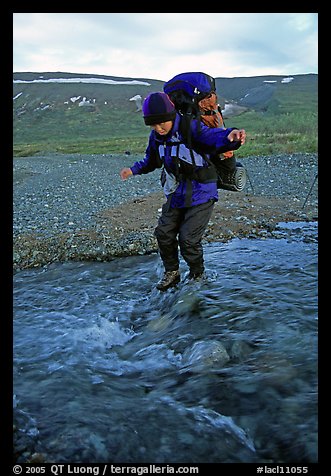 Backpacker crossing a stream on pebbles. Lake Clark National Park, Alaska