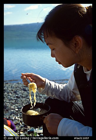 Backpacker eating noodles from a camp pot. Lake Clark National Park, Alaska (color)