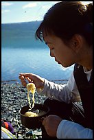 Backpacker eating noodles from a camp pot. Lake Clark National Park, Alaska ( color)