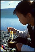 Backpacker eating noodles from a camp pot. Lake Clark National Park, Alaska