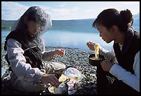 Backpackers eating noodles from a camp pot. Lake Clark National Park, Alaska (color)