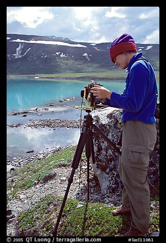 Large format photographer with camera on the shores of Turquoise Lake. Lake Clark National Park, Alaska