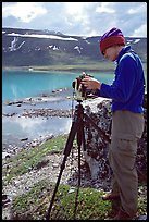 Large format photographer with camera on the shores of Turquoise Lake. Lake Clark National Park, Alaska
