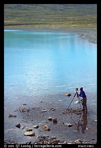 Large format photographer with tripod on the shores of Turquoise Lake. Lake Clark National Park, Alaska (color)