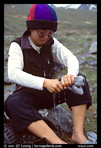 Woman backpacker drying socks after a stream crossing. Lake Clark National Park, Alaska (color)