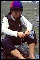 Woman backpacker drying socks after a stream crossing. Lake Clark National Park, Alaska ( color)