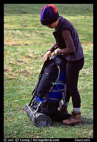 Backpacker finishes packing up backpack. Lake Clark National Park, Alaska