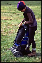 Backpacker finishes packing up backpack. Lake Clark National Park, Alaska (color)
