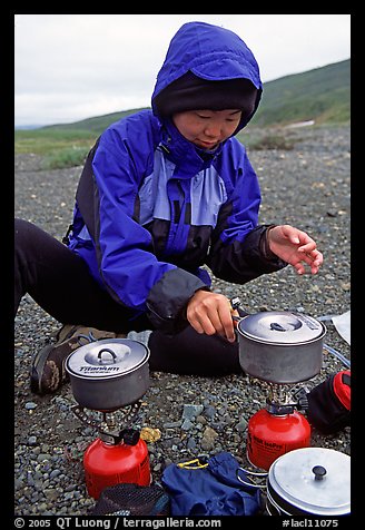 Backpacker cooks meal on gas campstove. Lake Clark National Park, Alaska (color)