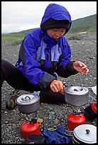 Backpacker cooks meal on gas campstove. Lake Clark National Park, Alaska