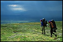 Two backpackers arrive at a ridge as a storm clears. Lake Clark National Park, Alaska (color)