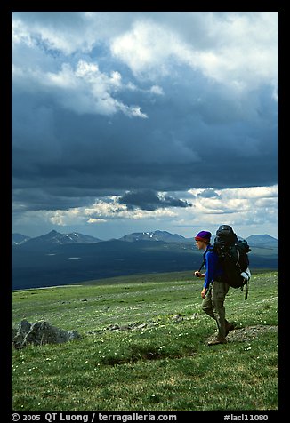 Backpacker seen from the side walking fast in the tundra. Lake Clark National Park, Alaska (color)