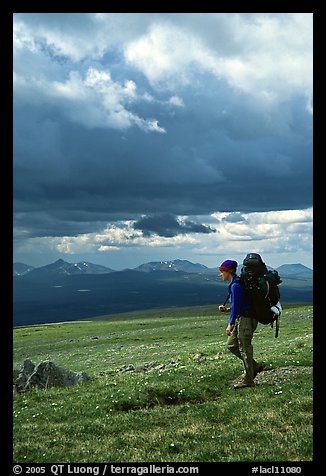 Backpacker seen from the side walking fast in the tundra. Lake Clark National Park, Alaska