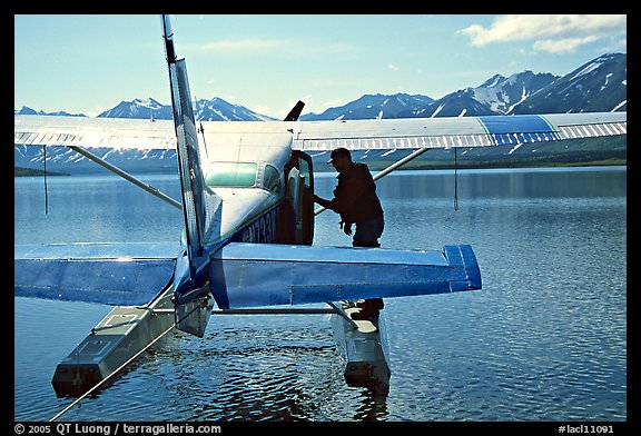 Pilot standing on floats of Floatplane, Twin Lakes. Lake Clark National Park, Alaska (color)