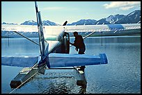 Pilot standing on floats of Floatplane, Twin Lakes. Lake Clark National Park, Alaska (color)