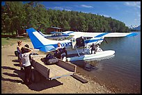 Backpackes being unloaded from floatplane to a trailer in Port Alsworth. Lake Clark National Park, Alaska (color)