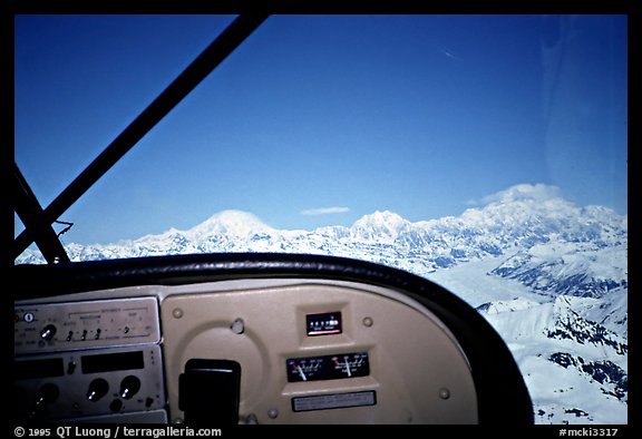 From the cockpit. The three main summits of the range are, from left to right, Mt Foraker, Mt Hunter, and Mt McKinley, which is cloud-capped, as often. Alaska (color)