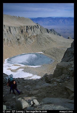 Woman on steep slope above frozen Iceberg Lake. Sequoia National Park, California