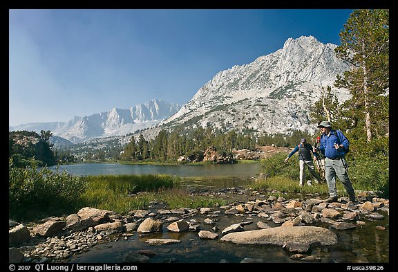 Hikers crossing stream on rocks at Long Lake, John Muir Wilderness. Kings Canyon National Park, California (color)