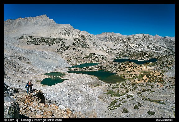 Hikers looking at view  above Saddlebag Lakes, John Muir Wilderness. Kings Canyon National Park, California