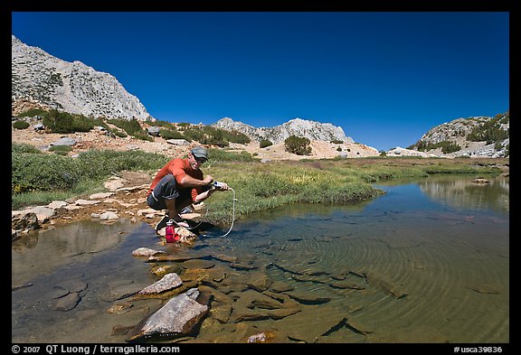 Man filtering water from stream, John Muir Wilderness. Kings Canyon National Park, California