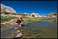 Man filtering water from stream, John Muir Wilderness. Kings Canyon National Park, California (color)