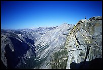 Hiker standing on top of Half-Dome, overlooking Tenaya Canyon. Yosemite National Park, California