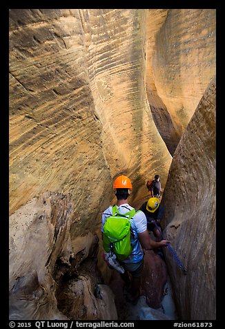 Canyoneers surrouned by tall walls in narrow section of Mystery Canyon. Zion National Park, Utah (color)