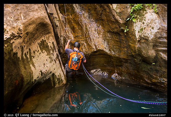 Canyoneer rappels into pool of water, Mystery Canyon. Zion National Park, Utah (color)
